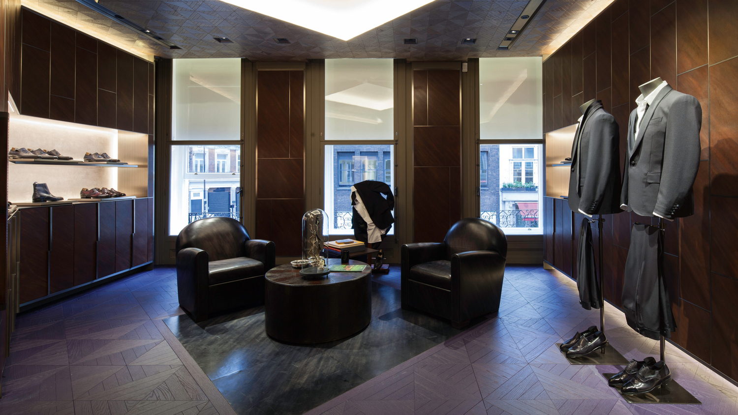 Boutique Berluti aménagée par Poltrona Frau, avec des meubles en cuir et bois, exemple du luxe et de l'artisanat italiens.