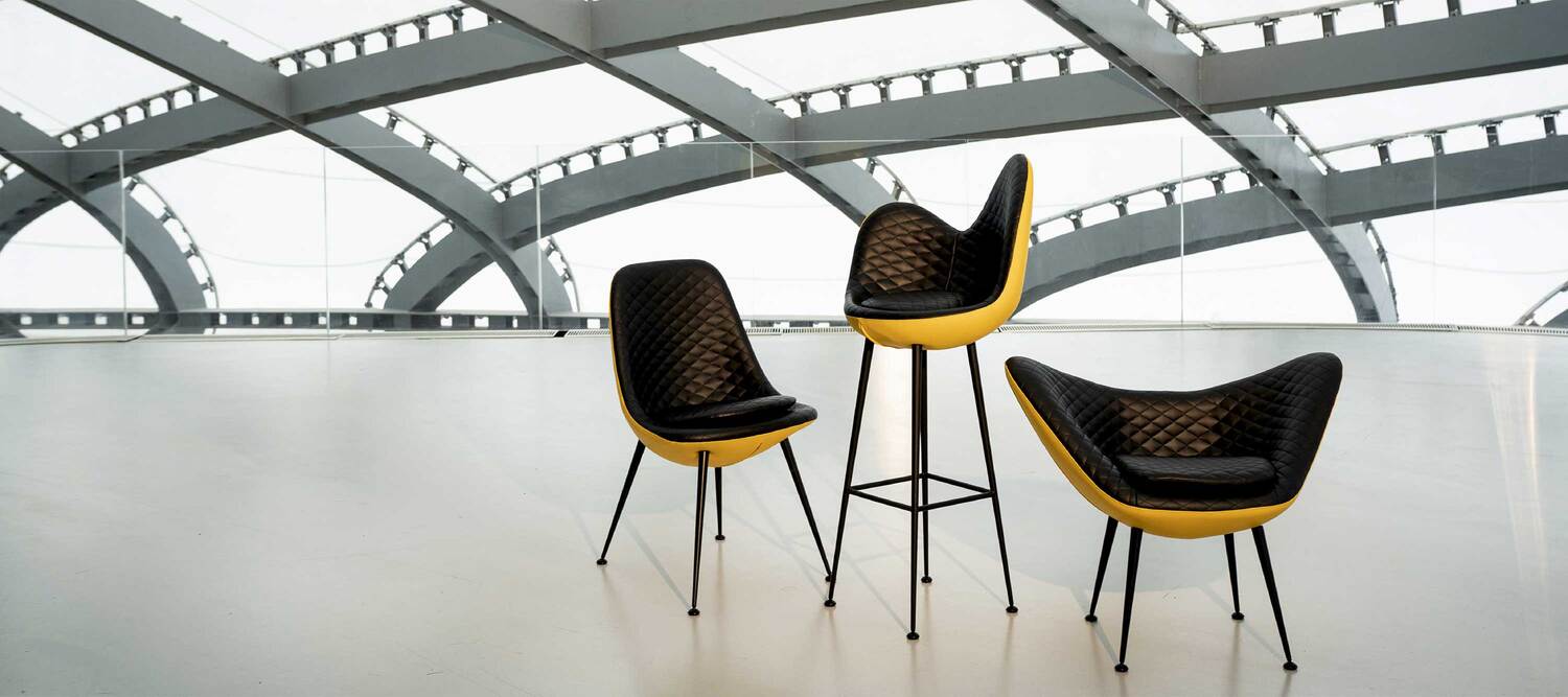 Margherita | Stool Margherita stool by Poltrona Frau captures the grace of flower petals: a soft seat with diamond stitching and a conical metal base, for an elegant piece that combines craftsmanship and contemporary comfort.