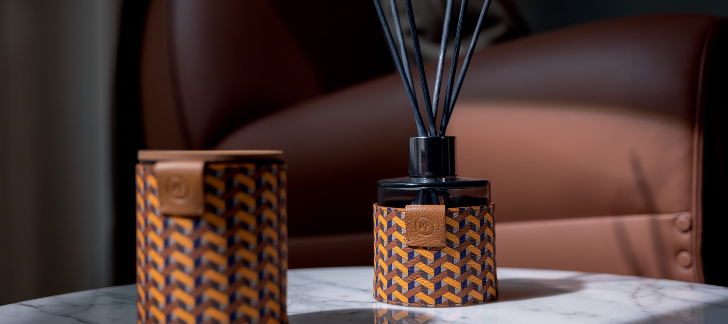 Weavers Home Fragrance | Diffusore Weavers Home Fragrance di Poltrona Frau è un diffusore elegante in vetro rivestito in Pelle Frau®, con fragranze raffinate diffuse da bastoncini in rattan.